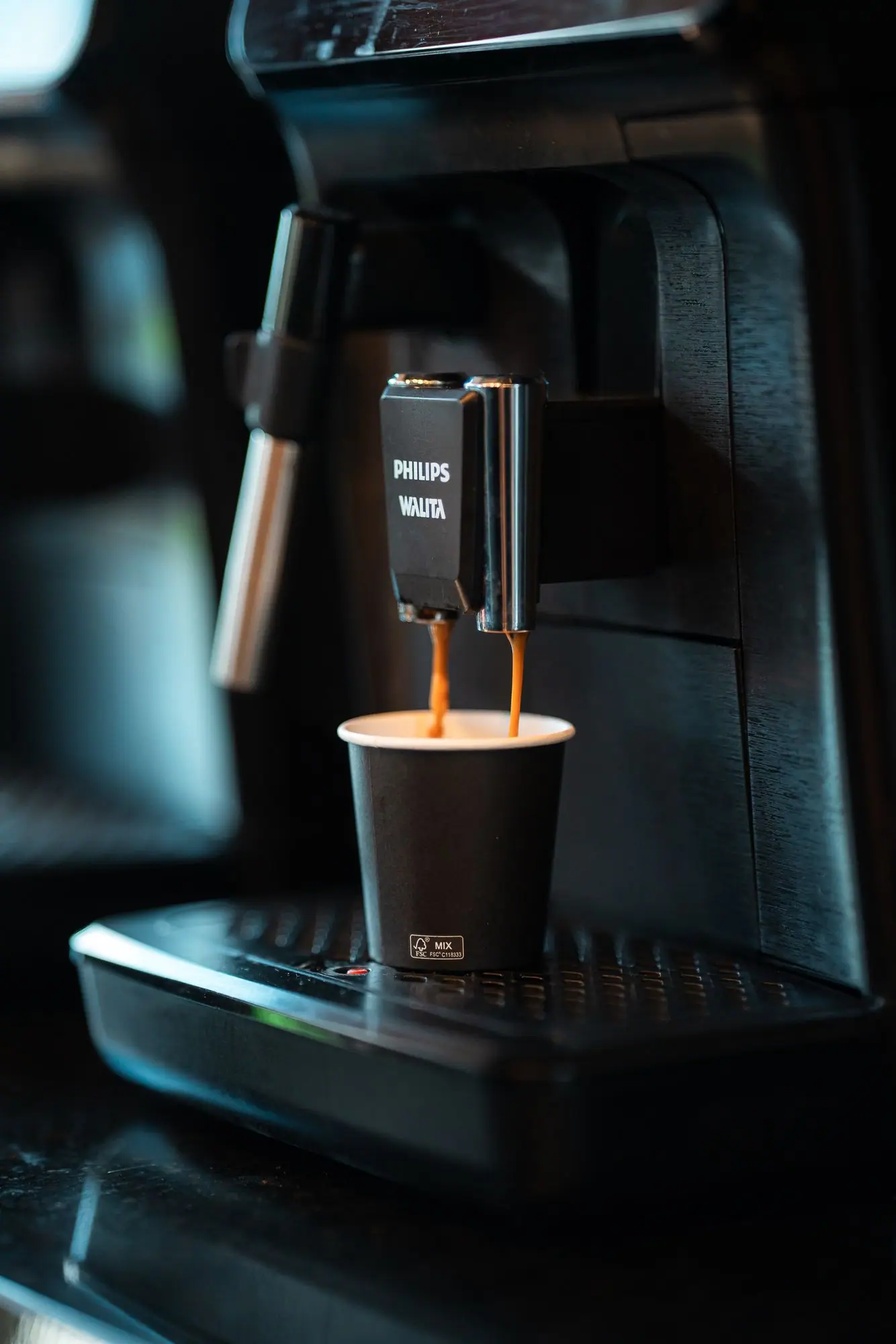 Máquina de café servindo um copo durante o intervalo.
