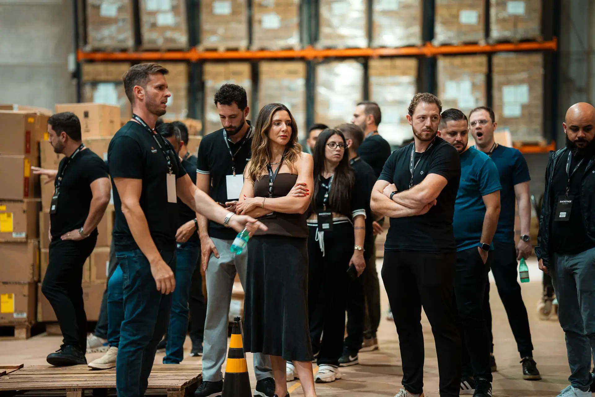 Empresários em visita guiada ao estoque da Usee Brasil, entre prateleiras e caixas, durante uma experiência anterior de bastidores.